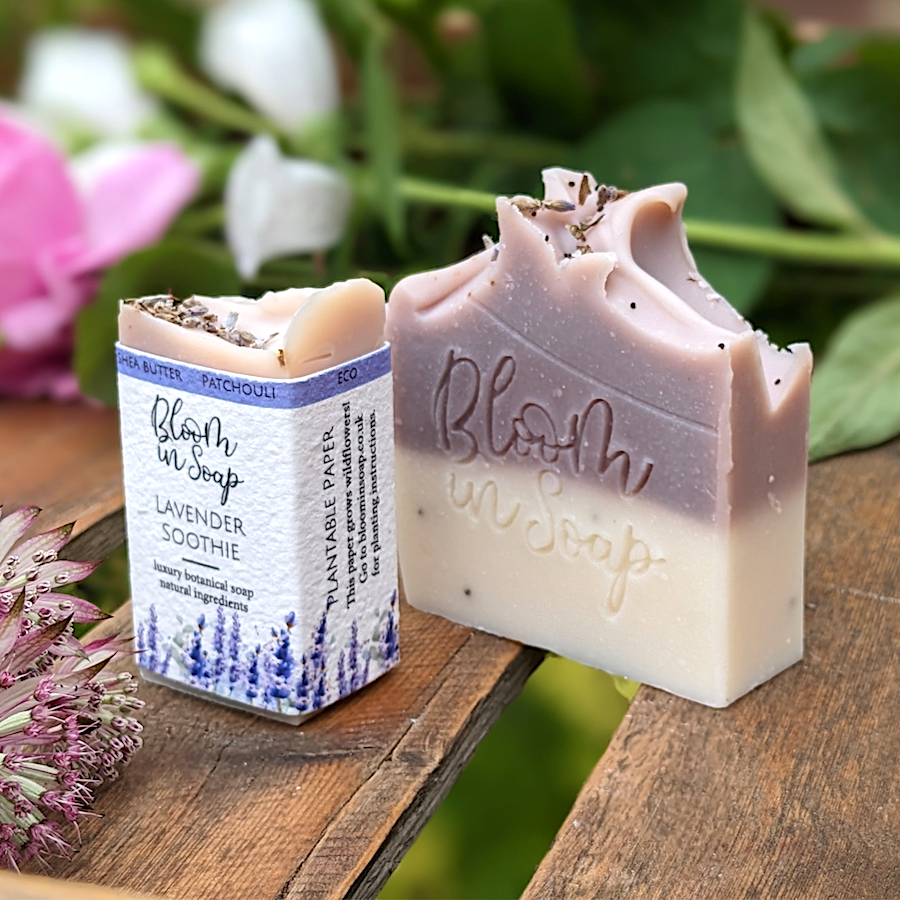 Lavender handmade soap on a wooden tray with flowers and plants