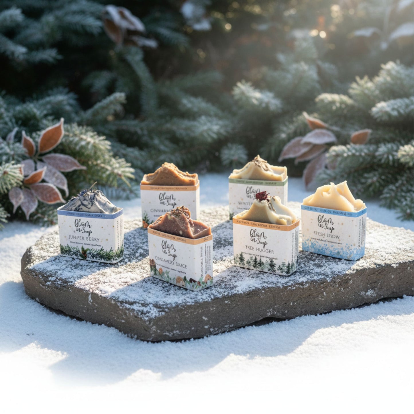Set of shandmade natural soap bars on a stone surface covered in snow, with a blurred natural background.