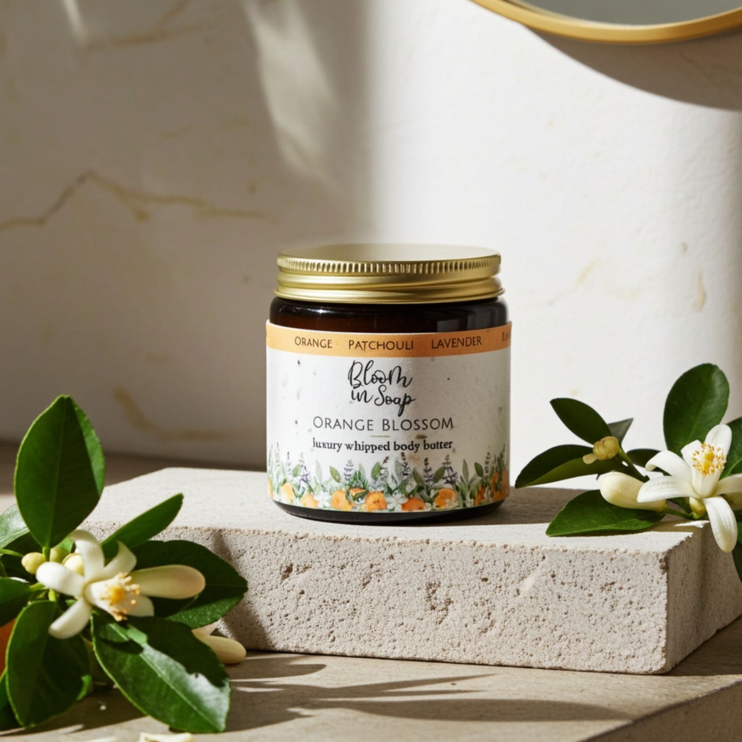 Jar of 'Orange Blossom' body butter with floral elements on a light background