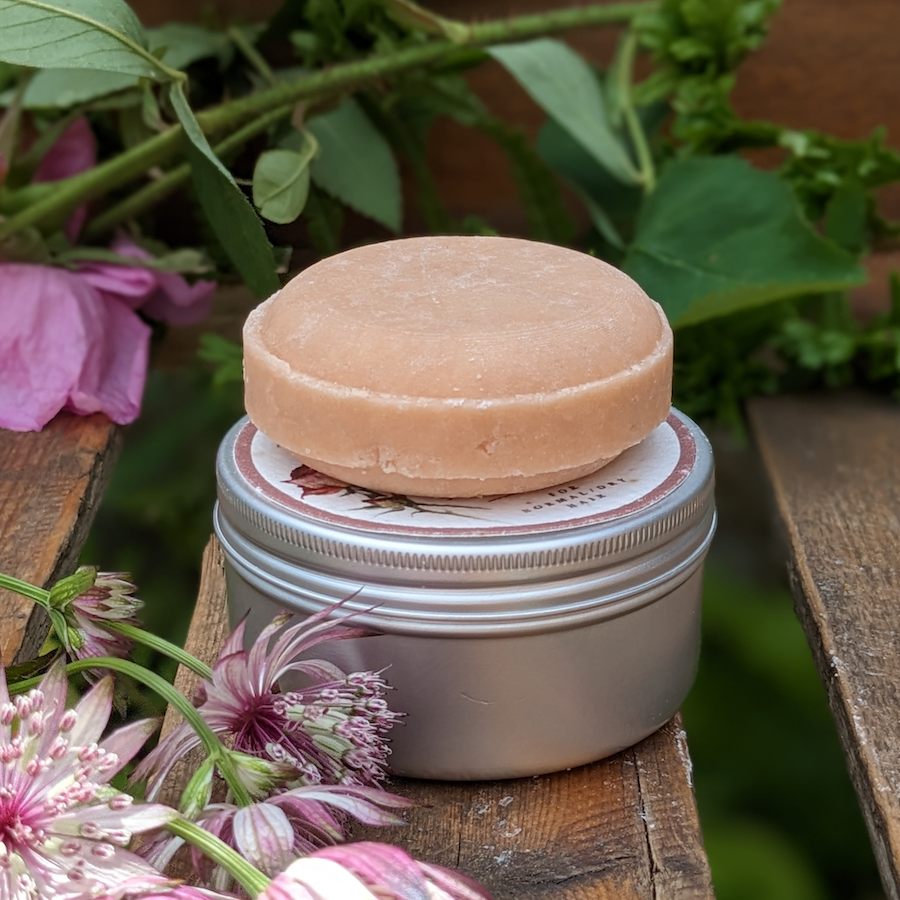Pink rose shampoo bar on an aluminium tin
