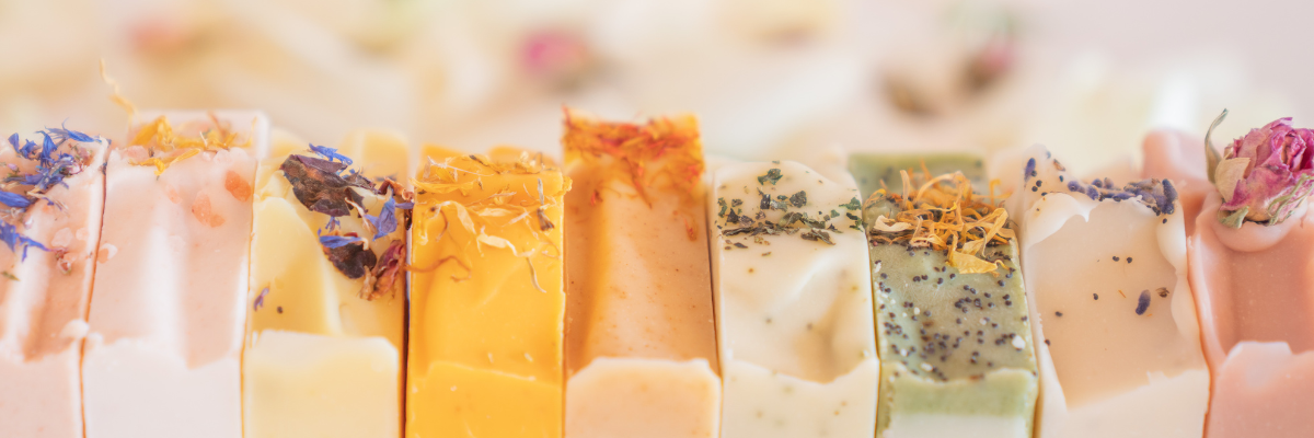 a line of natural soap bars in different natural colours with flowers on top