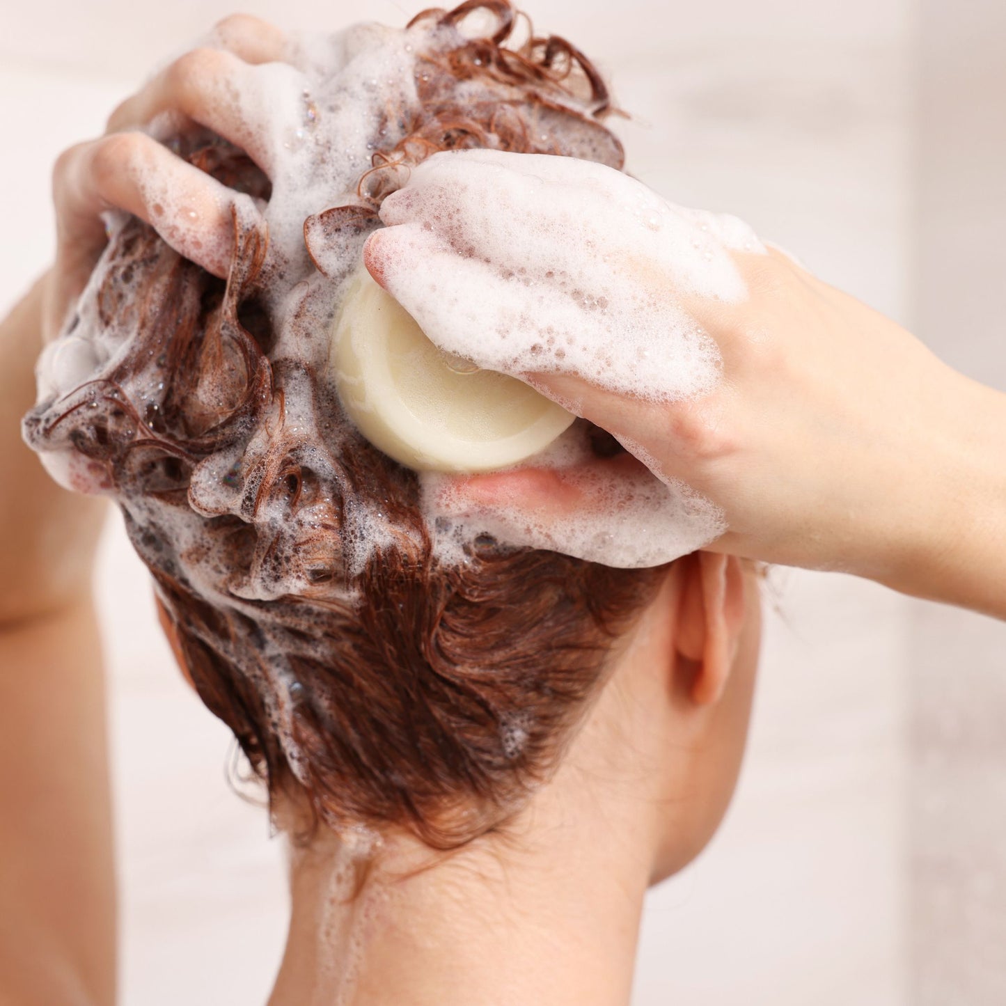Woman washing hair with shampoo bar