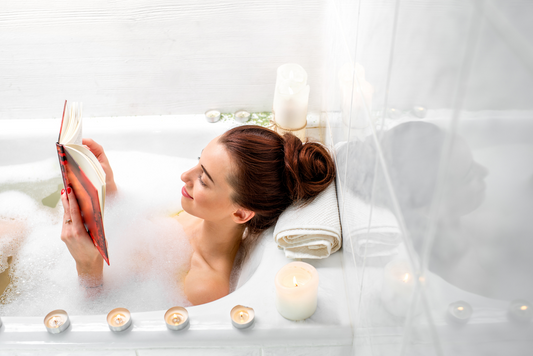 woman relaxing in a bath reading a book