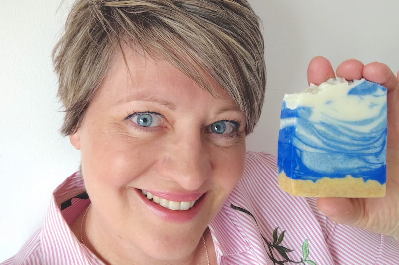 woman holding a bar of blue soap