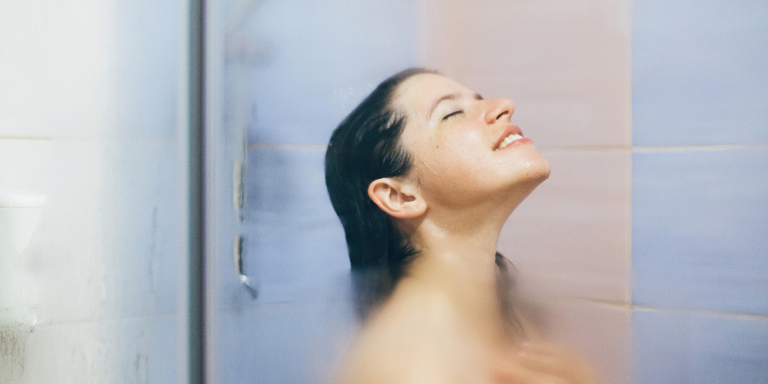 A woman in a shower using shower steamers
