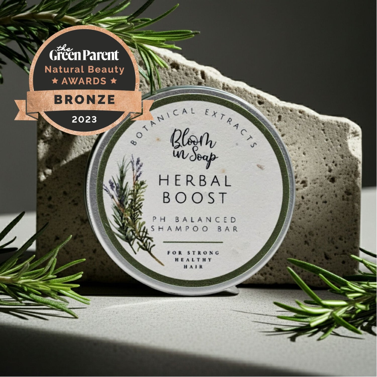 Herbal Boost shampoo bar in a tin with natural stone and greenery in the background