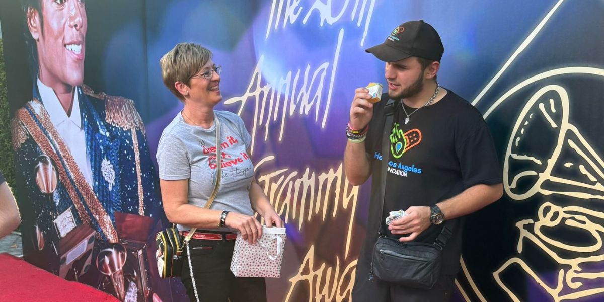 Two people standing in front of a colorful backdrop with text and graphics.