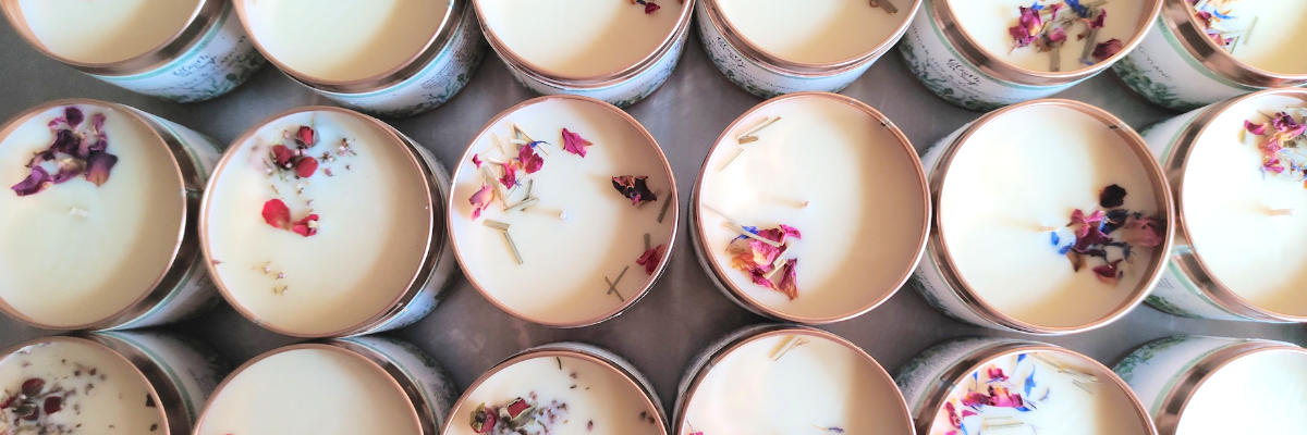 lots of candles with flowers lined up together