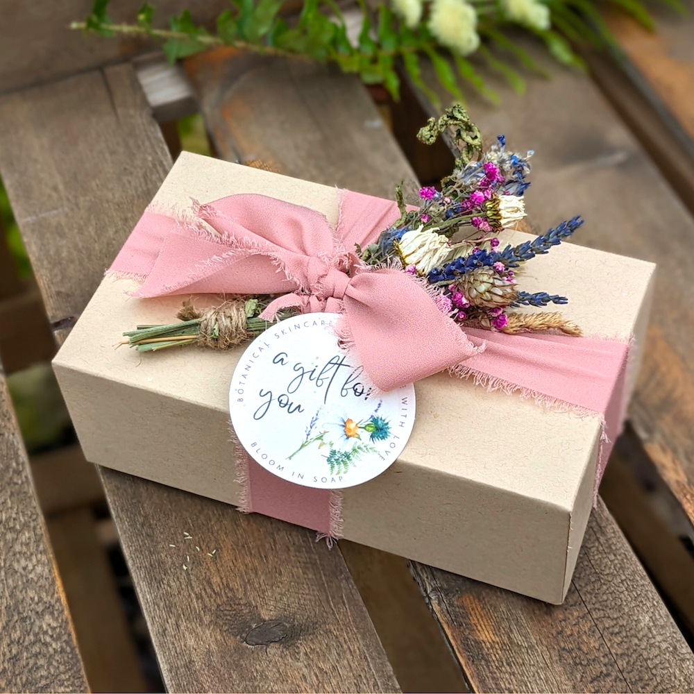 gift box tied with pink ribbon and dried flowers with plantable gift tag