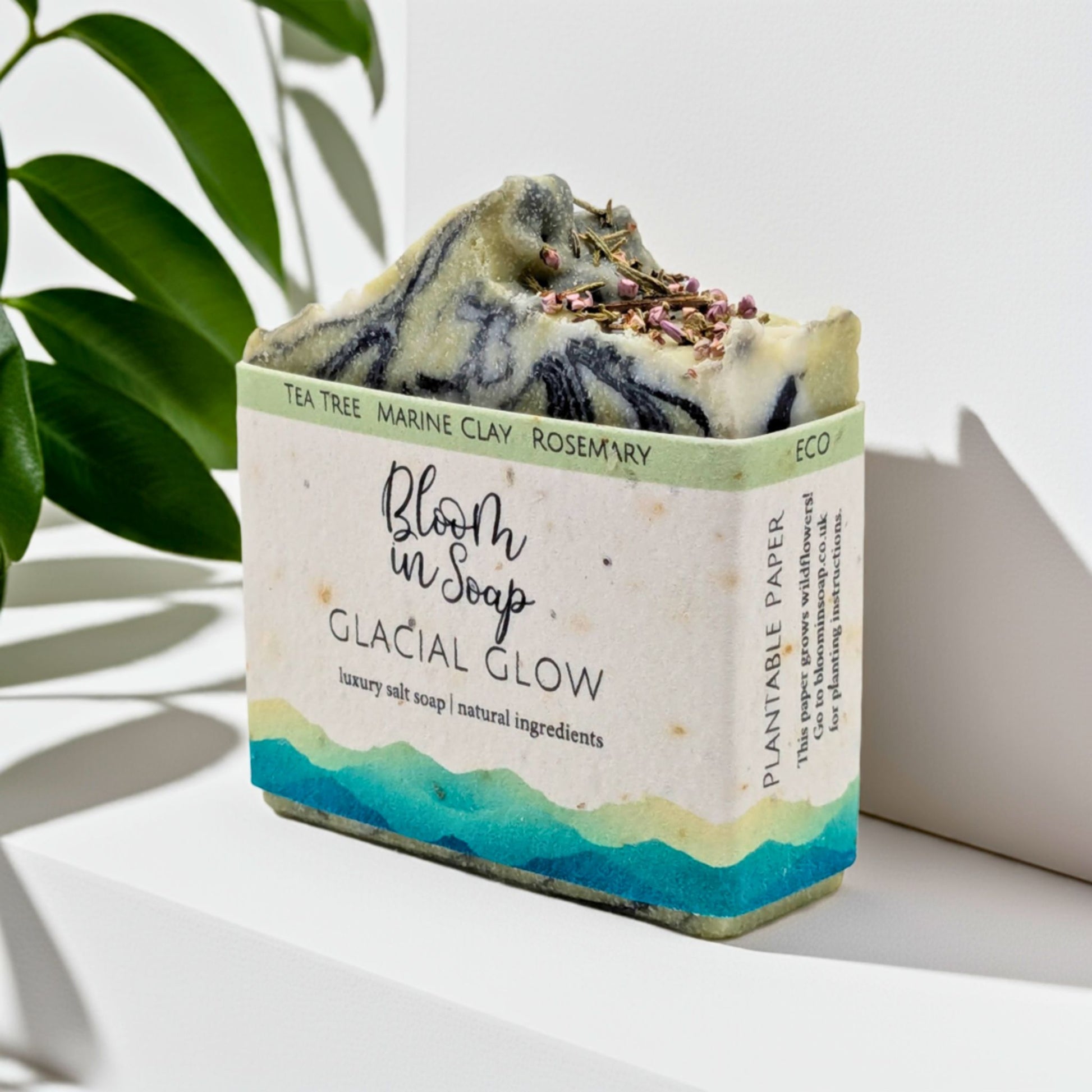 Bar of soap with a visible label on a white surface with a plant in the background