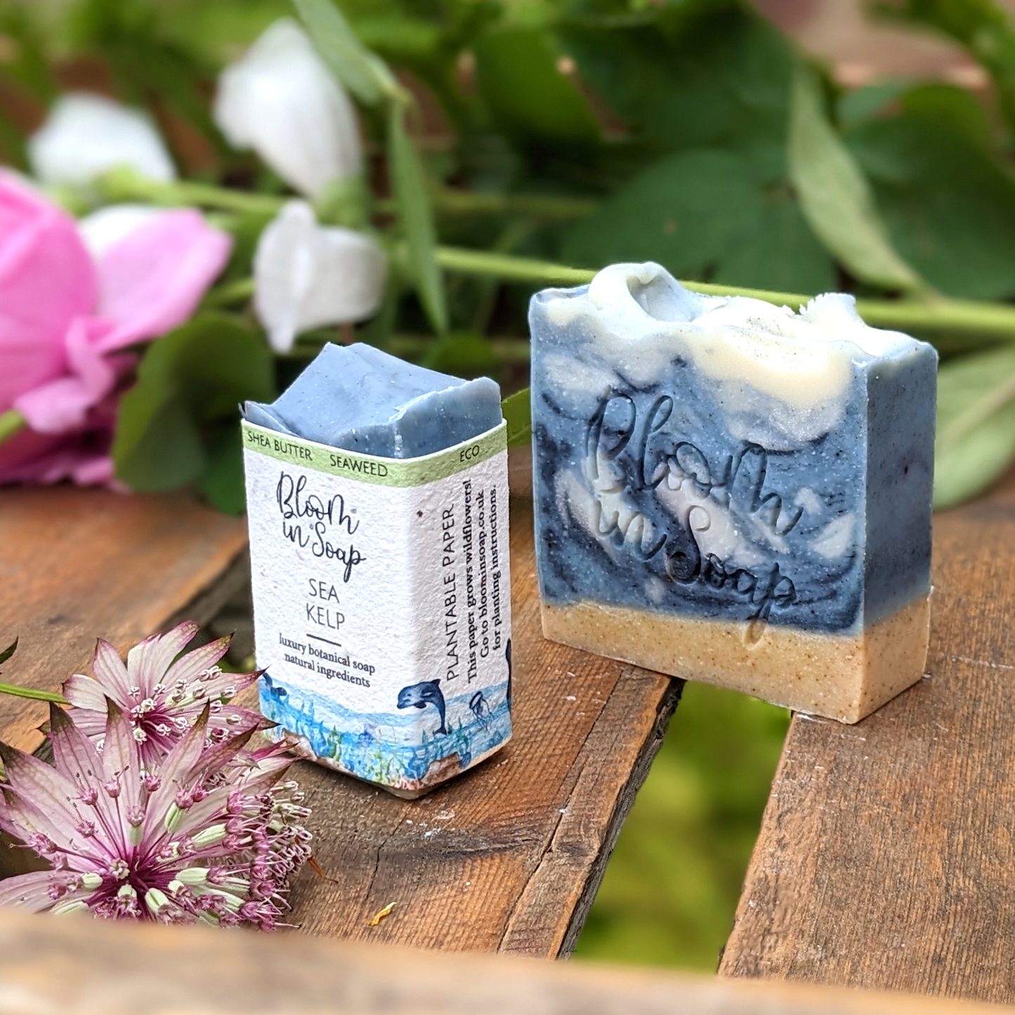Blue ocean themed handmade soap with sea kelp on a wooden tray