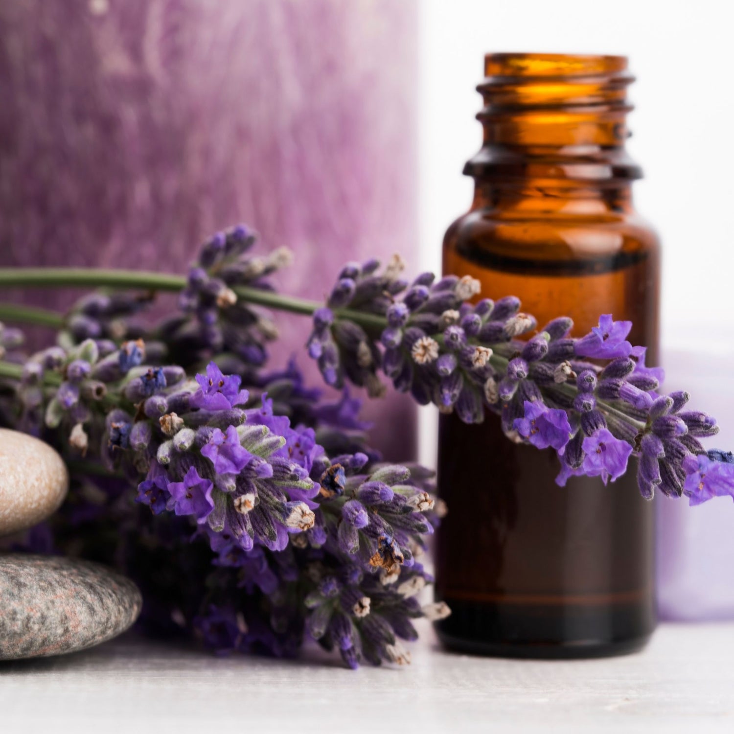 Brown glass bottle with lavender flowers on a light surface