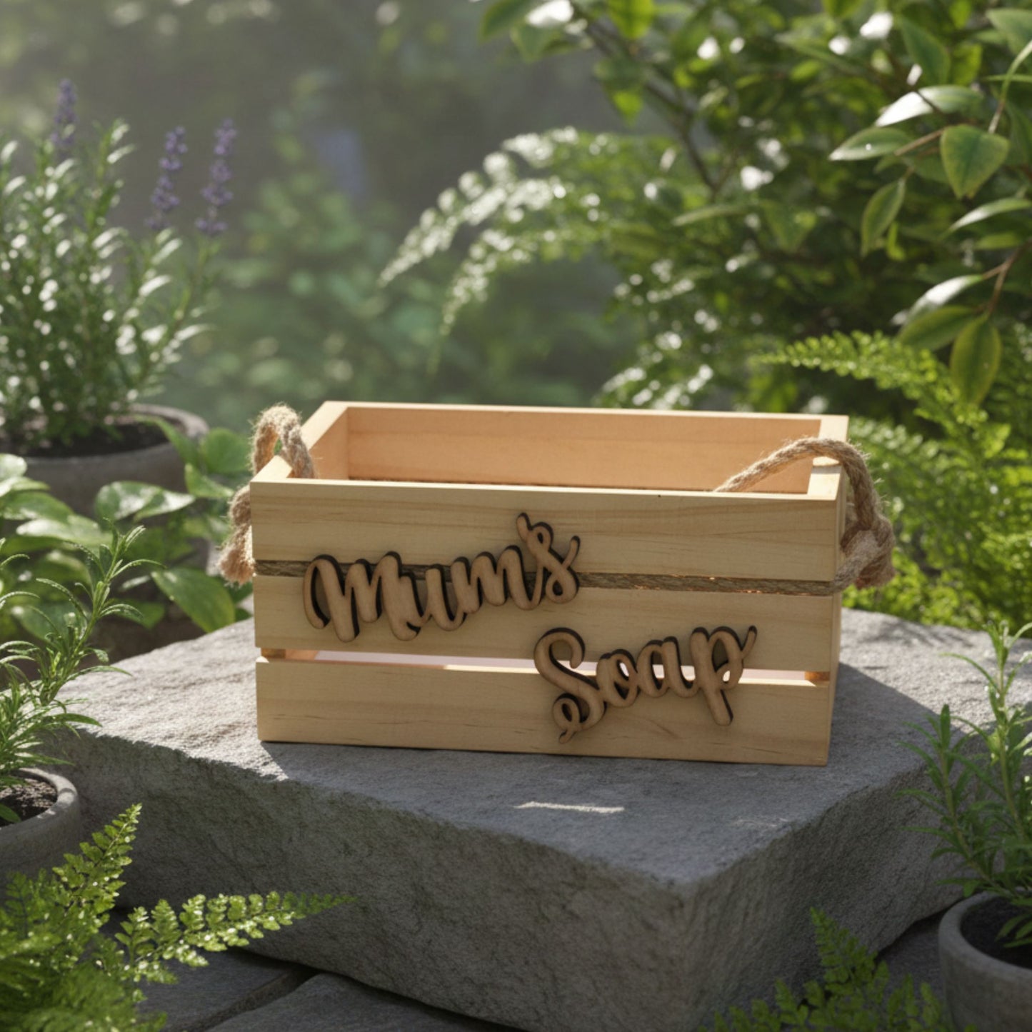 Wooden box labeled 'Mum's Soap' on a stone surface with greenery in the background