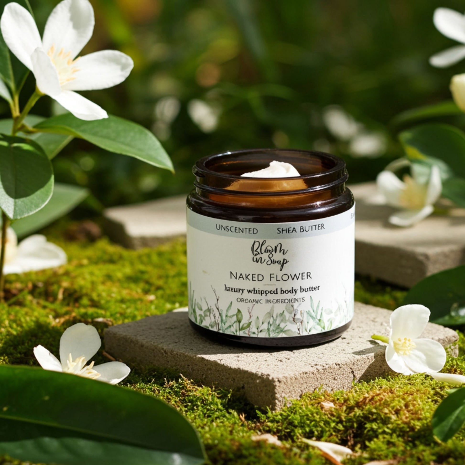 jar of body butter with petals and greenery in the background