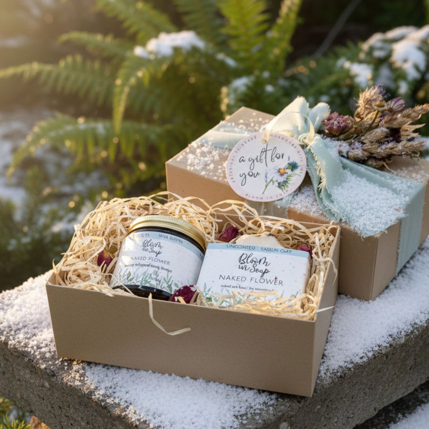 Gift set with soap and body butter in a decorative box on a snowy surface