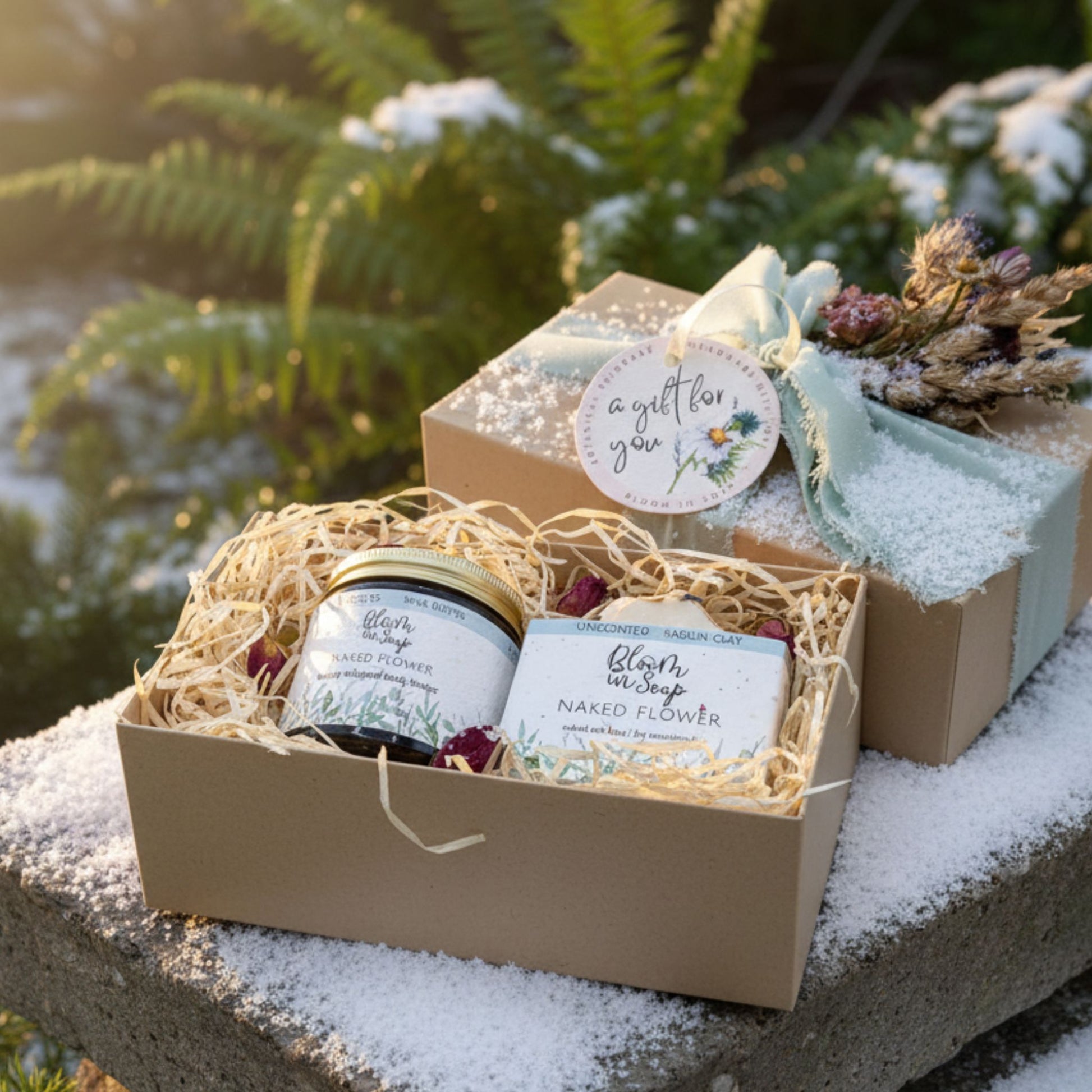 Gift set with soap and body butter in a decorative box on a snowy surface