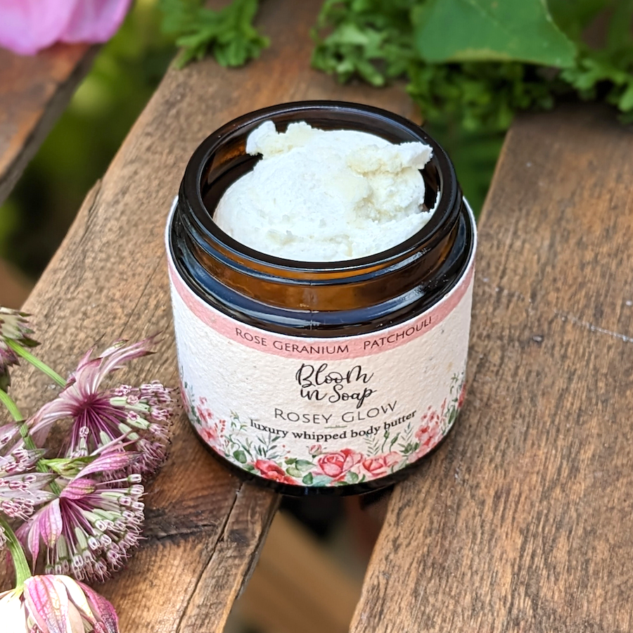 Rosey Glow whipped body butter in a jar on a wooden tray