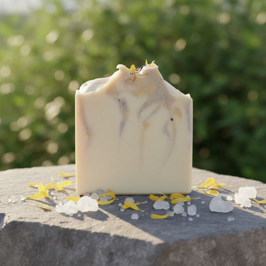 Handmade soap bar with natural elements on a stone surface with a blurred green background