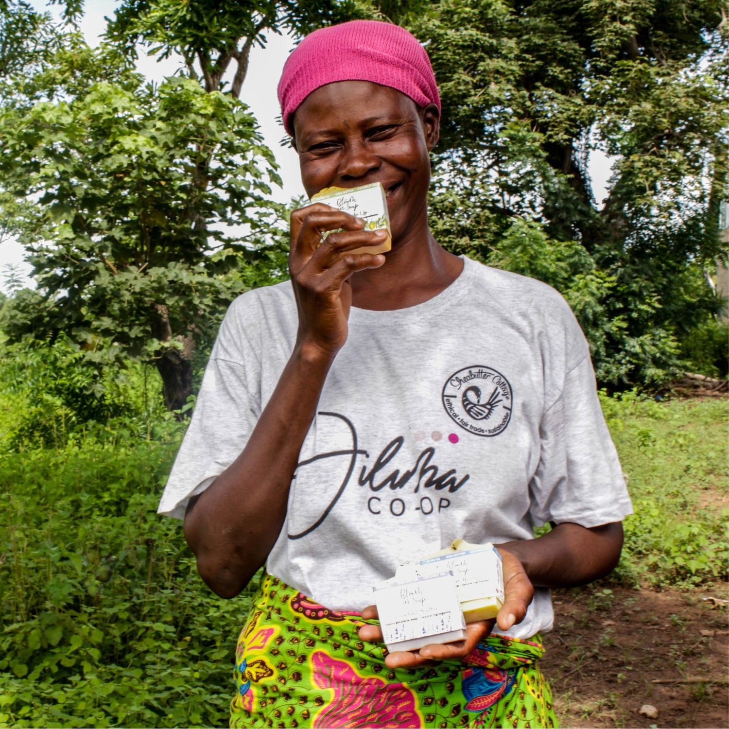 Woman smelling a natural soap bar to the camera outdoors