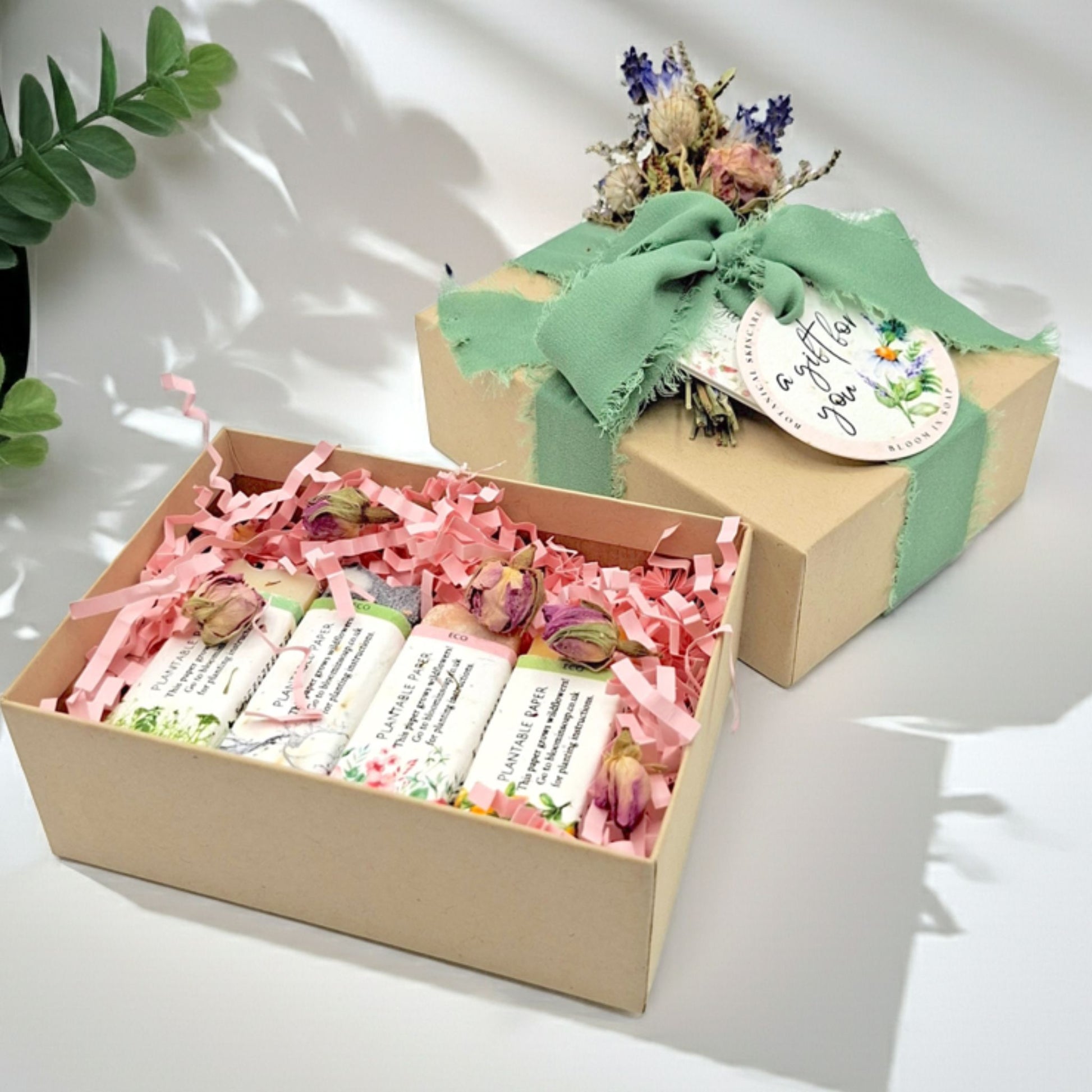 Gift box with pink ribbons and flowers on a white background