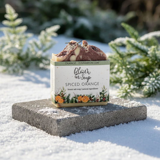 Spiced orange soap bar with packaging on a snowy surface