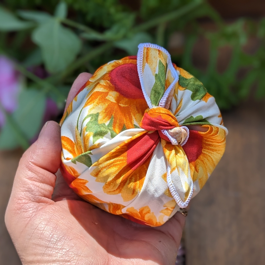 A gift wrap wrapped in a yellow sunflower print furoshiki